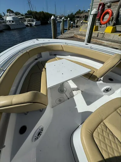  Yacht Photos Pics Luxury boat seating area with beige cushions and a central table, docked at a marina.