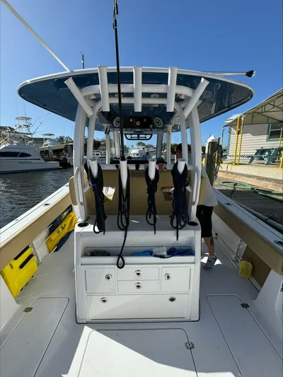  Yacht Photos Pics 2023 Sportsman boat interior with fishing rod holders and storage, docked at marina.