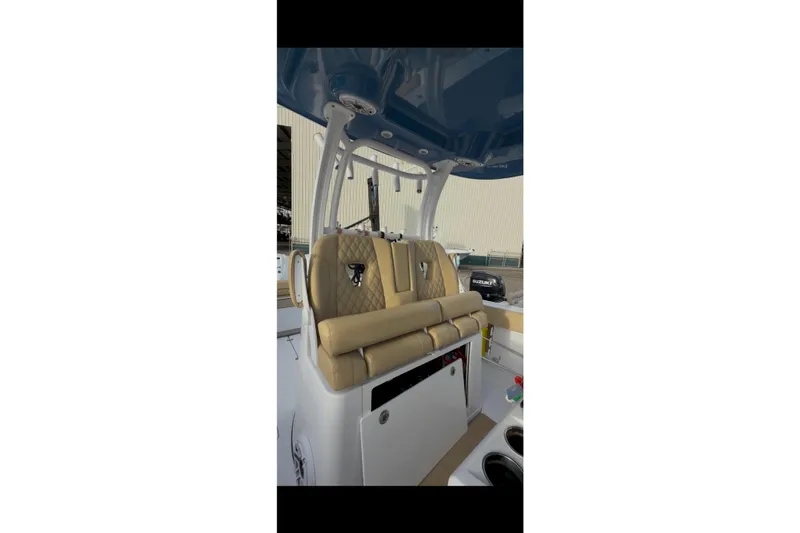  Yacht Photos Pics 2023 Sportsman Open 322 Center Console boat interior with tan seating and blue canopy.