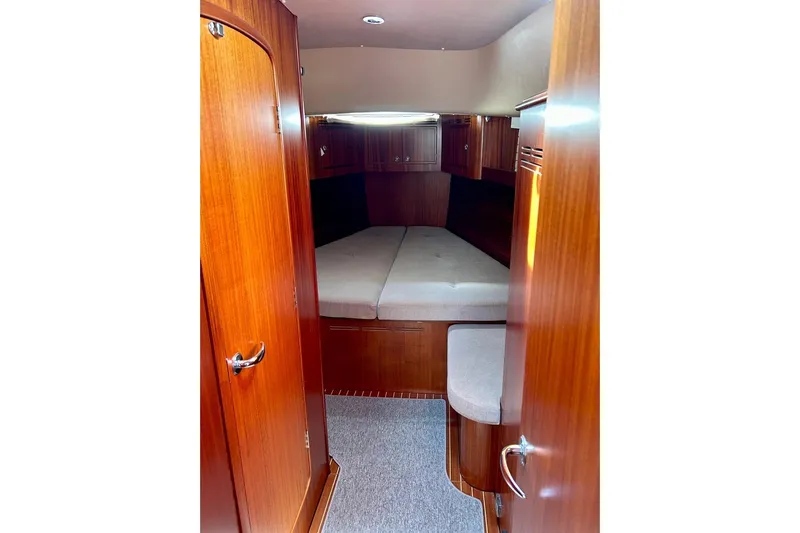 Magic I Yacht Photos Pics Cozy cabin interior of 2021 Hallberg-Rassy 44 yacht with wooden finish and comfortable bedding.
