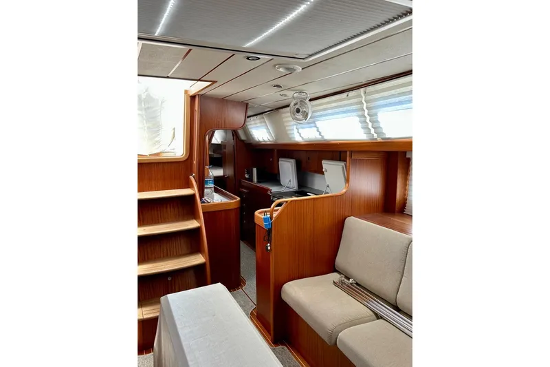 Magic I Yacht Photos Pics Interior of 2021 Hallberg-Rassy 44 yacht with wooden finish and comfortable seating.