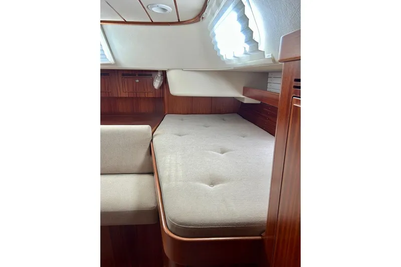 Magic I Yacht Photos Pics Interior cabin of 2021 Hallberg-Rassy 44 yacht with wooden finish and comfortable bedding.