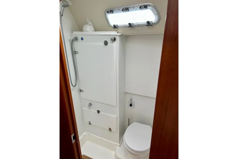 Magic I Yacht Photos Pics Bathroom interior of 2021 Hallberg-Rassy 44 yacht, featuring shower and toilet.