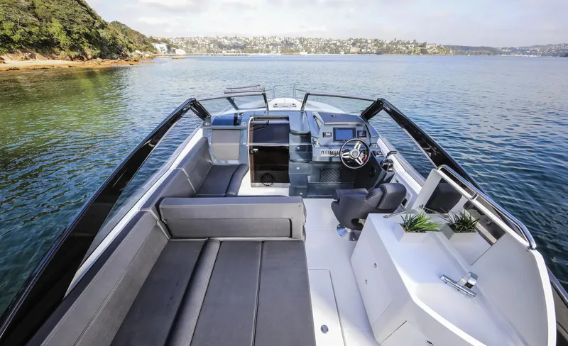  Yacht Photos Pics 2024 Skamander 850 Voyager boat interior with sleek design on calm water.