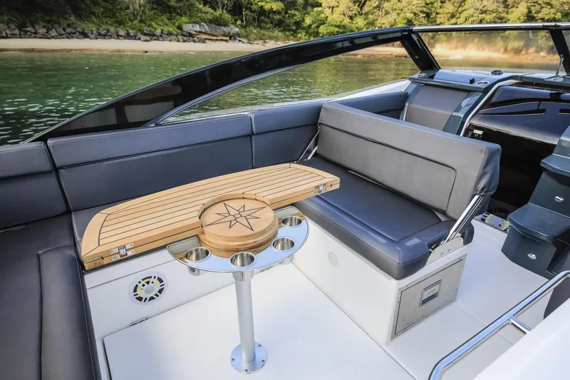  Yacht Photos Pics Luxurious interior of 2024 Skamander 850 Voyager boat with sleek seating and wooden table.