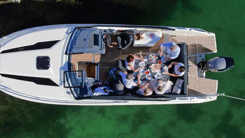  Yacht Photos Pics Top view of 2024 Skamander 850 Voyager boat with people dining onboard.