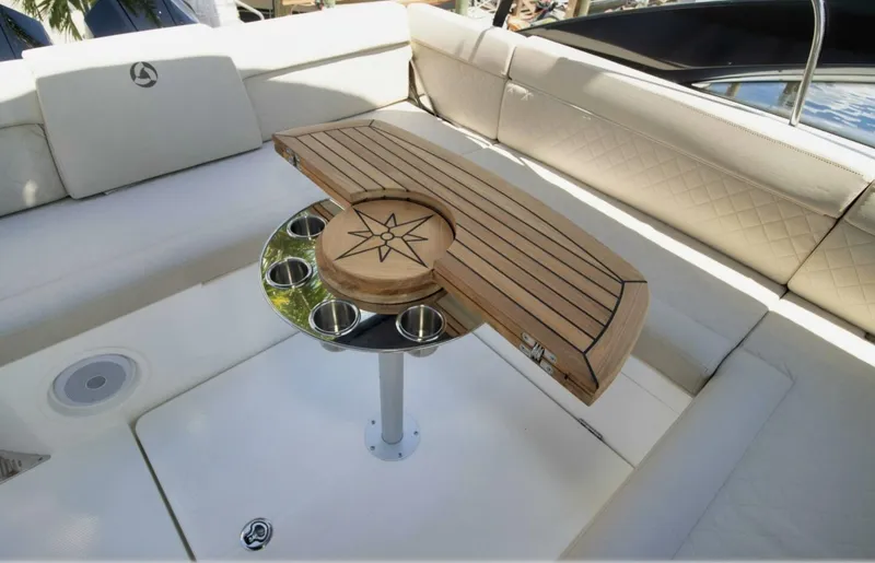  Yacht Photos Pics Luxurious seating area on 2024 Skamander 850 Voyager boat with wooden table and cup holders.