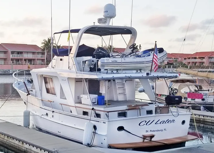  Yacht Photos Pics 1987 DeFever Tri-Cabin yacht docked, featuring upper deck and American flag, St. Petersburg, FL.