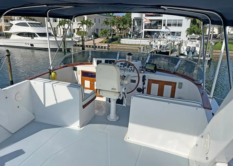  Yacht Photos Pics 1987 DeFever Tri-Cabin yacht helm with marina view, featuring navigation equipment and seating.