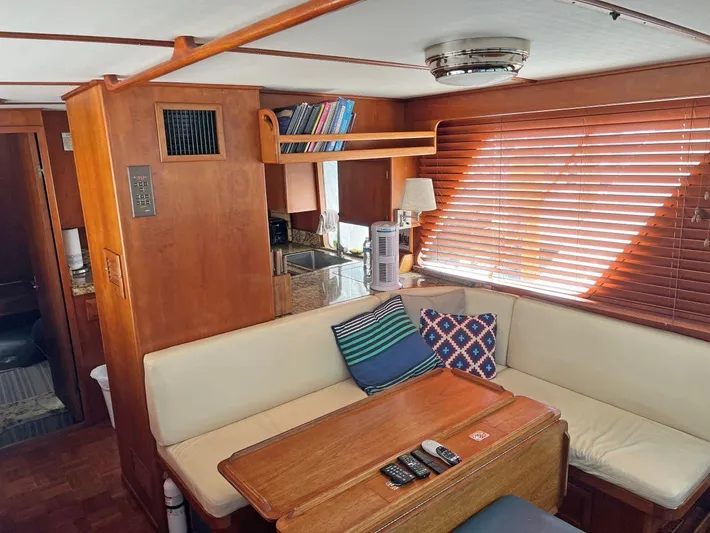  Yacht Photos Pics 1987 DeFever Tri-Cabin interior with cozy seating, wooden table, and nautical decor.