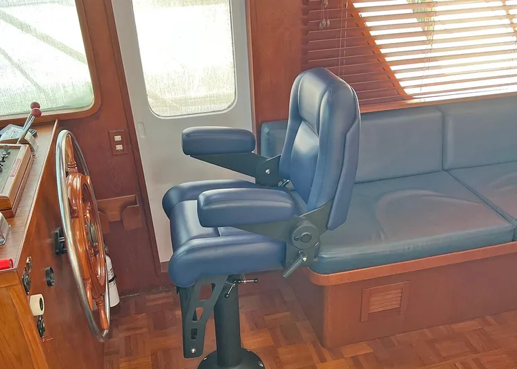  Yacht Photos Pics 1987 DeFever Tri-Cabin interior with blue captain's chair and wooden helm.