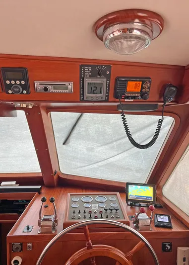  Yacht Photos Pics 1987 DeFever Tri-Cabin helm with navigation instruments and wooden steering wheel.