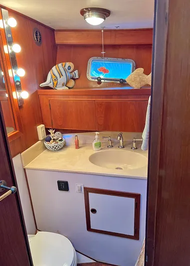  Yacht Photos Pics 1987 DeFever Tri-Cabin bathroom with wooden cabinetry, vanity, and nautical decor.