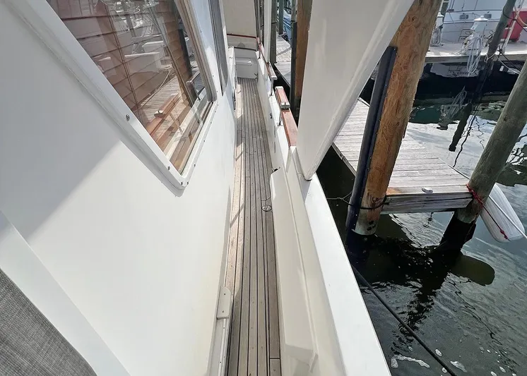  Yacht Photos Pics 1987 DeFever Tri-Cabin yacht side deck with wooden flooring and marina view.