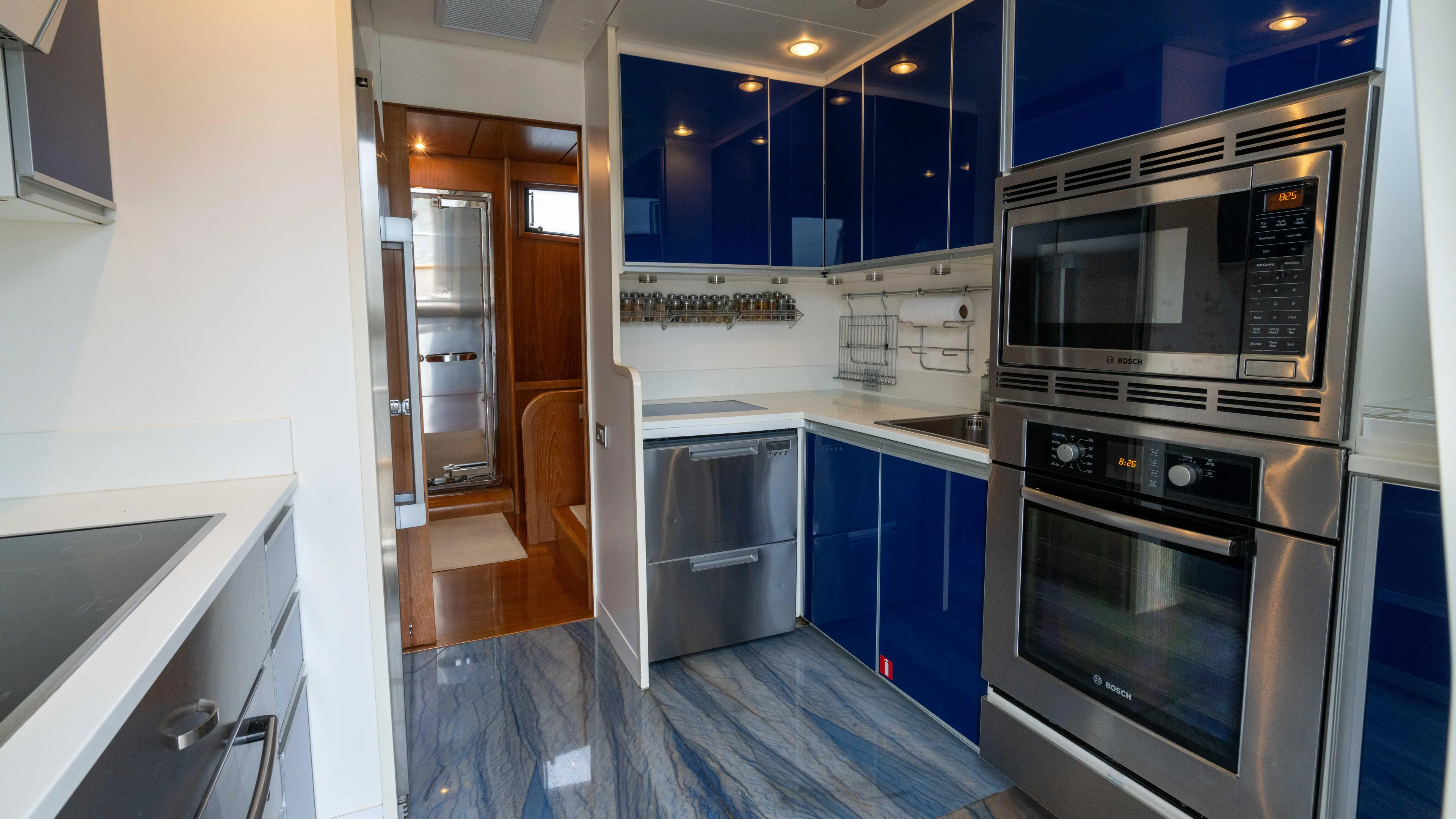 Losand Yacht Photos Pics Modern kitchen interior on 2005 Sanlorenzo SL82 yacht with blue cabinetry and stainless steel appliances.