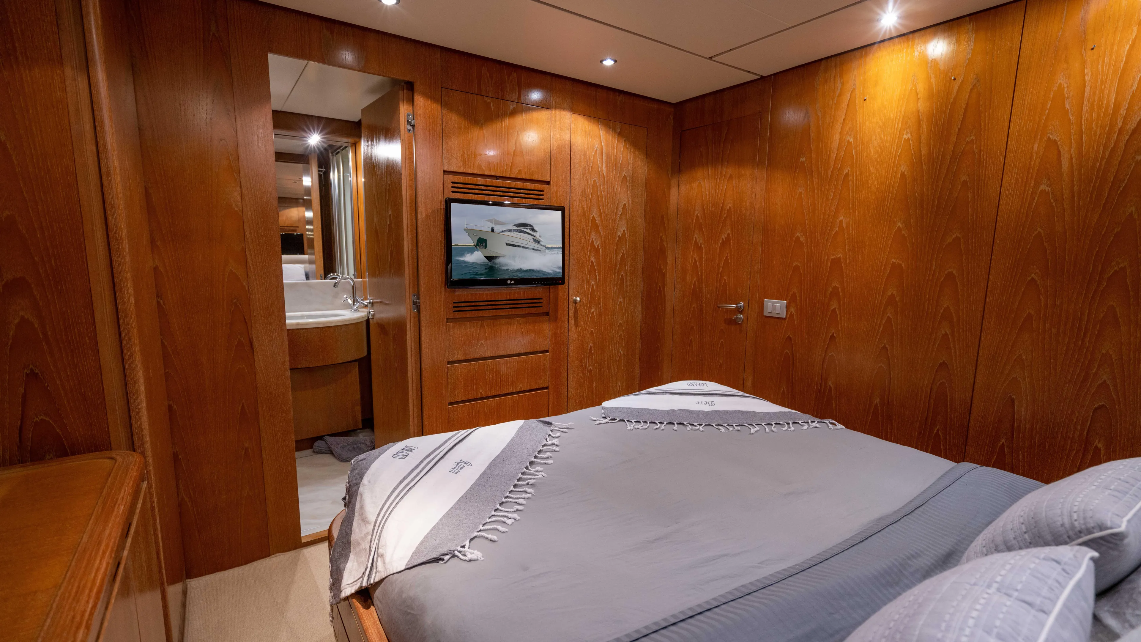 Losand Yacht Photos Pics Luxurious Sanlorenzo SL82 2005 yacht bedroom with wood paneling and ensuite bathroom.