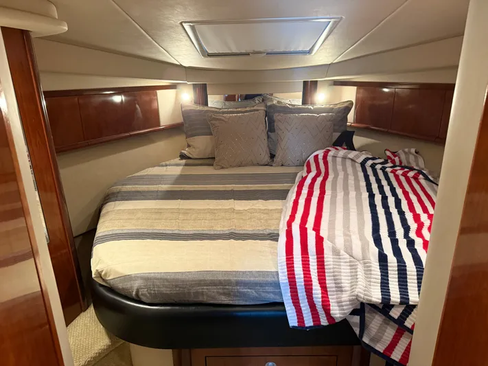 Great Escape Yacht Photos Pics Luxurious cabin interior of 2004 Sea Ray 390 Sundancer with cozy bedding and ambient lighting.