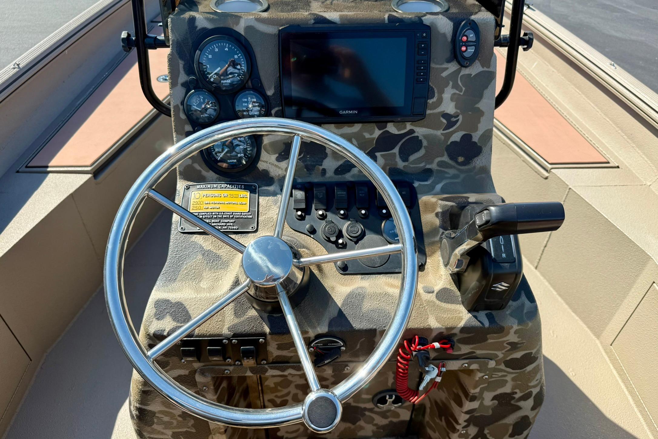 2019 Excel 230 Bay Pro boat dashboard with camo design, steering wheel, and navigation controls.