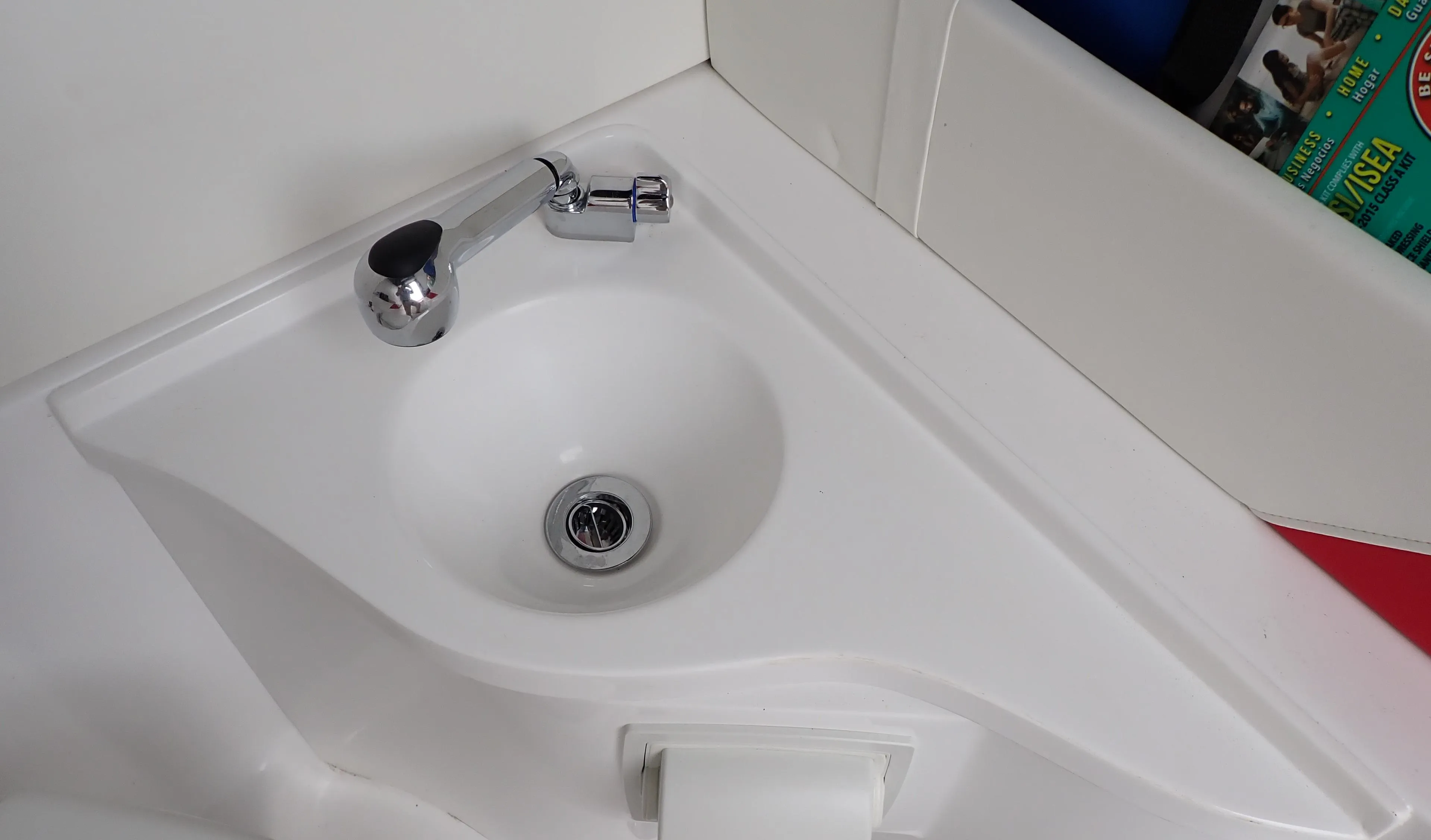 Compact white sink with chrome faucet in 2024 Statement 350 Open boat.