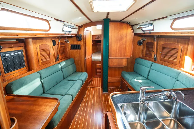 Delta Sand Yacht Photos Pics Interior of a 2000 Sabre 362 sailboat with wooden finish and green seating.