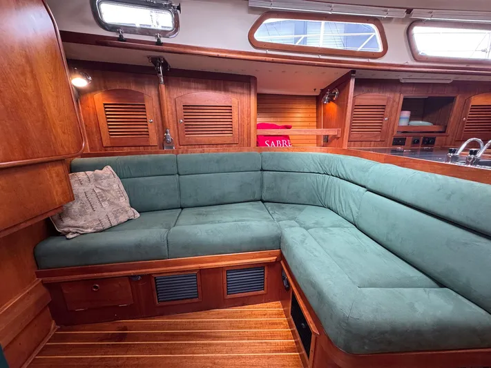 Delta Sand Yacht Photos Pics Interior of 2000 Sabre 362 yacht with green cushioned seating and wooden cabinetry.