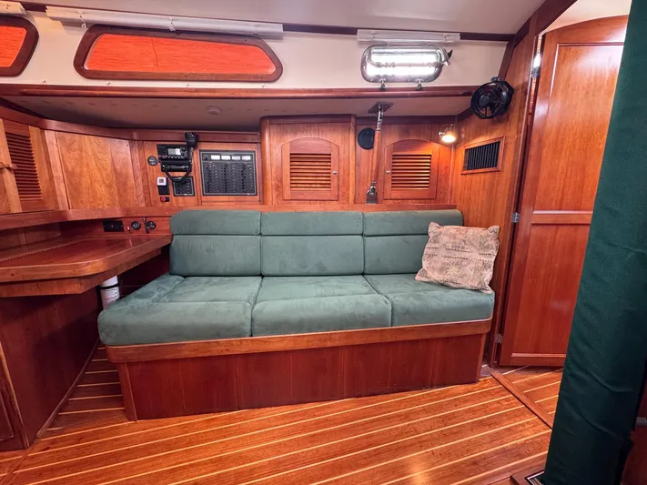 Delta Sand Yacht Photos Pics Interior of 2000 Sabre 362 sailboat with green sofa and wooden paneling.