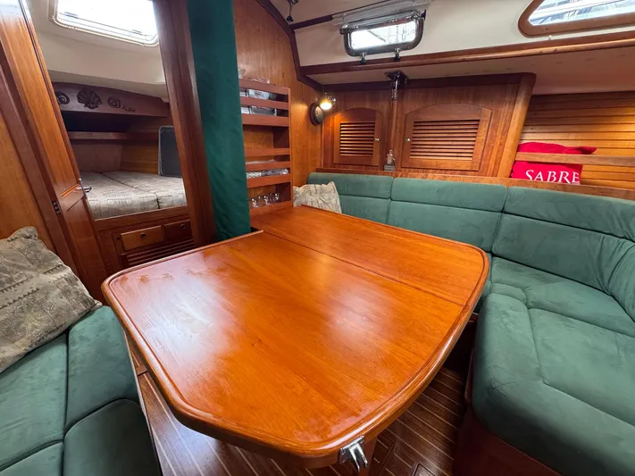 Delta Sand Yacht Photos Pics Interior of 2000 Sabre 362 sailboat with wooden table and green seating.