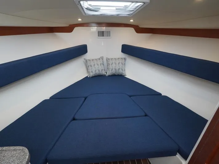  Yacht Photos Pics 2024 Albemarle 30 Express cabin interior with blue cushions and overhead skylight.