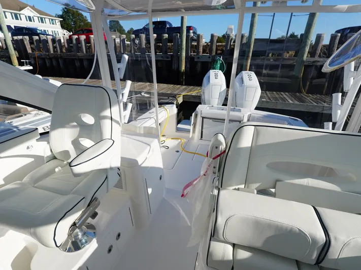  Yacht Photos Pics 2024 Albemarle 30 Express boat interior with white seating and dual engines at dock.