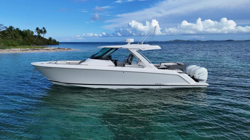  Yacht Photos Pics 2020 Tiara Yachts 38 LS in clear blue waters near a tropical island.