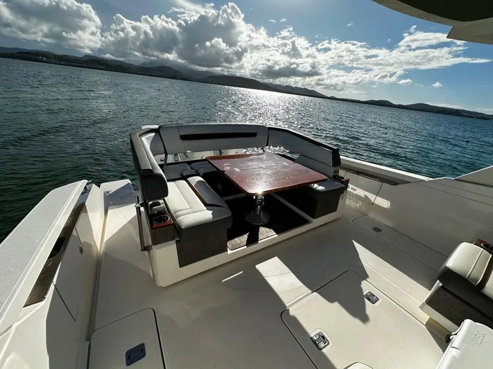  Yacht Photos Pics 2020 Tiara Yachts 38 LS deck with seating and table, overlooking serene waters.