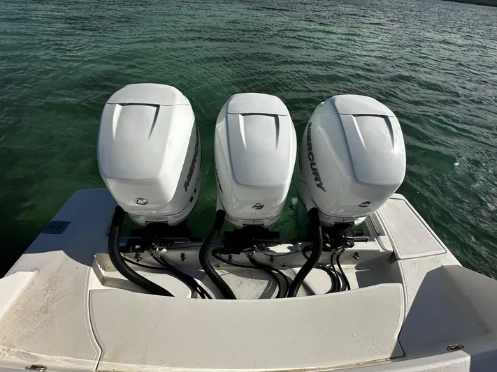  Yacht Photos Pics Triple Mercury outboard engines on a 2020 Tiara Yachts 38 LS, cruising on clear waters.