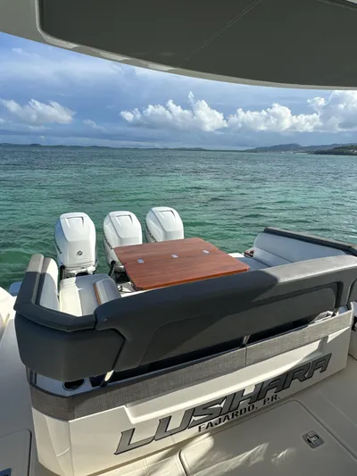  Yacht Photos Pics 2020 Tiara Yachts 38 LS on serene water, featuring triple outboard engines and elegant seating.