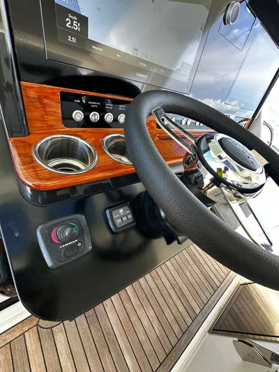  Yacht Photos Pics Steering wheel and dashboard of 2020 Tiara Yachts 38 LS with wood accents and controls.