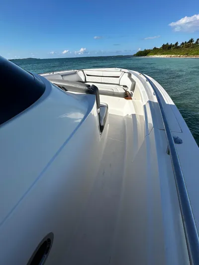  Yacht Photos Pics 2020 Tiara Yachts 38 LS cruising on a sunny day near a lush coastline.