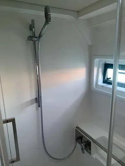  Yacht Photos Pics Modern shower area in 2023 Excess 15 yacht, featuring sleek design and window.