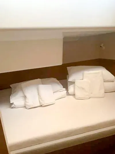  Yacht Photos Pics Compact cabin bed with neatly folded white linens, 2023 Excess 15 model.