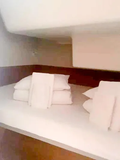  Yacht Photos Pics Cozy cabin bed with neatly arranged pillows and towels in Excess 15, 2023 model.