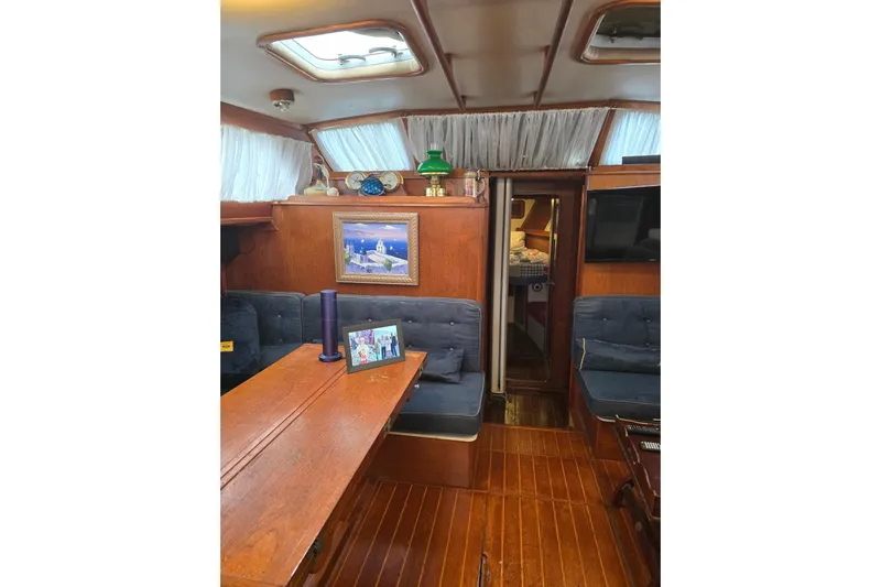 At Last Yacht Photos Pics Interior of 1982 Irwin 52 sailboat with wooden furnishings and cozy seating area.