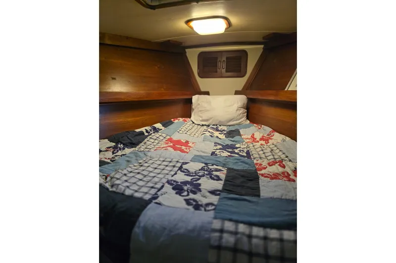 At Last Yacht Photos Pics Cozy cabin bed with colorful quilt in 1982 Irwin 52 sailboat.