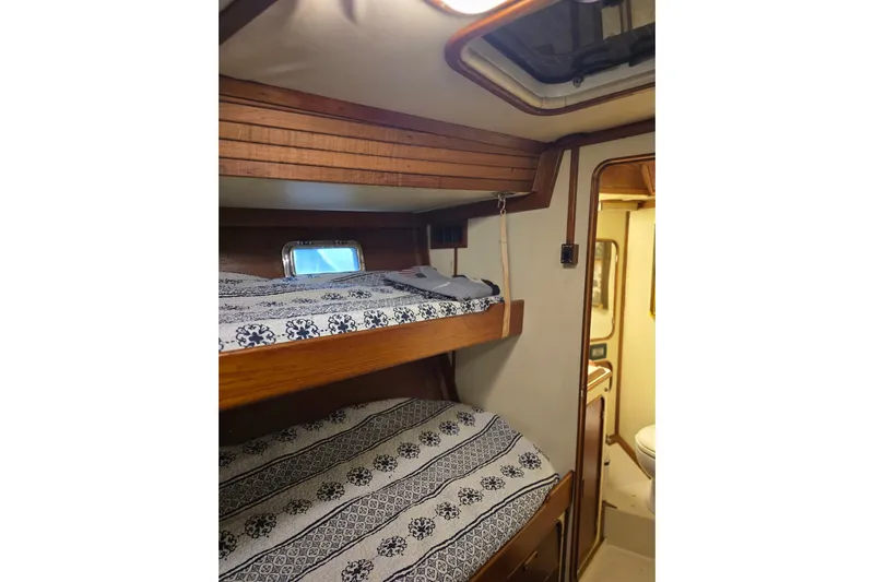 At Last Yacht Photos Pics Interior of 1982 Irwin 52 sailboat with cozy bunk beds and nautical decor.