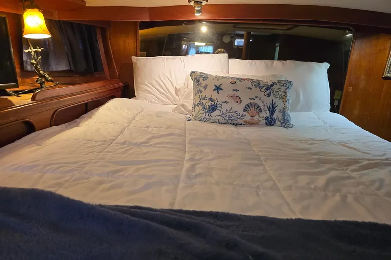 At Last Yacht Photos Pics Cozy cabin bedroom in 1982 Irwin 52 yacht with nautical-themed decor.