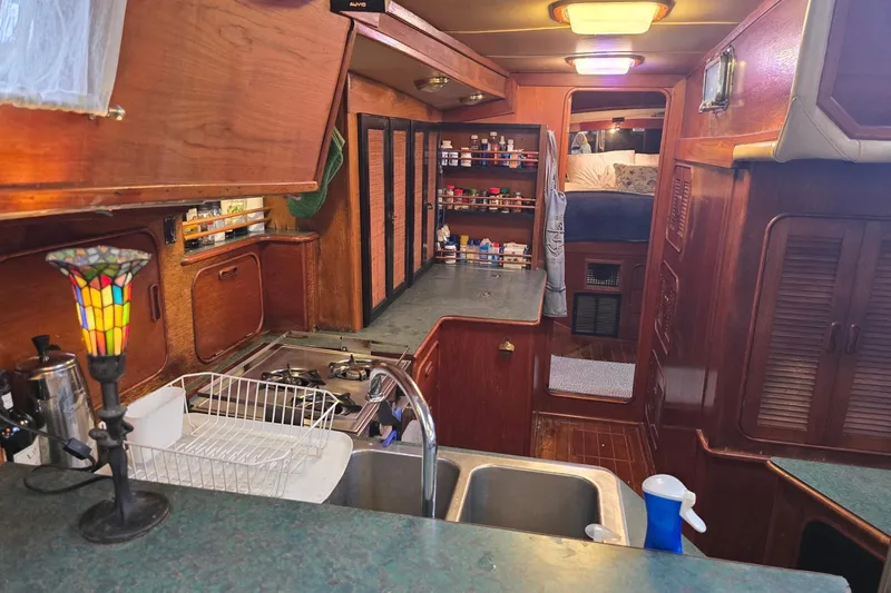At Last Yacht Photos Pics Interior of 1982 Irwin 52 sailboat with kitchen and cozy cabin area.