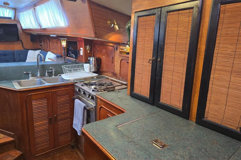 At Last Yacht Photos Pics 1982 Irwin 52 yacht interior kitchen with wooden cabinets and modern appliances.