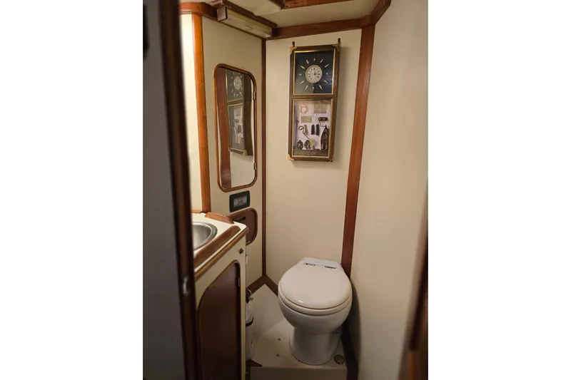 At Last Yacht Photos Pics Compact bathroom in a 1982 Irwin 52 yacht, featuring a toilet, sink, and nautical decor.