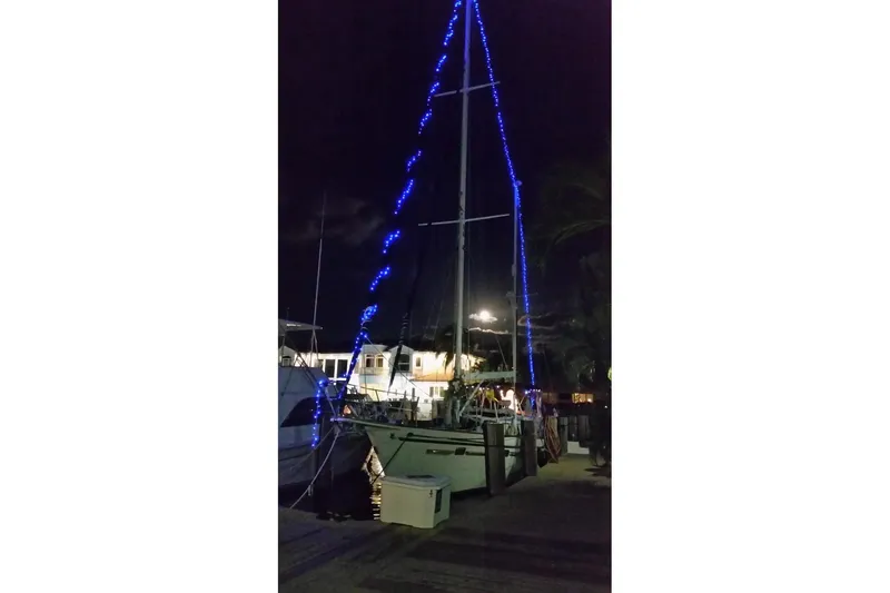 At Last Yacht Photos Pics 1982 Irwin 52 sailboat with blue lights docked at night.