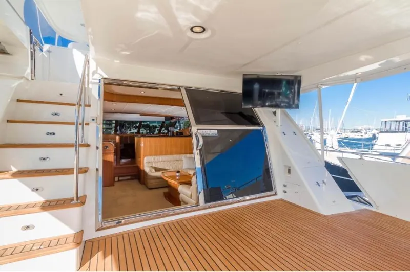  Yacht Photos Pics Luxurious 2005 Johnson 70 yacht interior with wooden deck, stairs, and marina view.