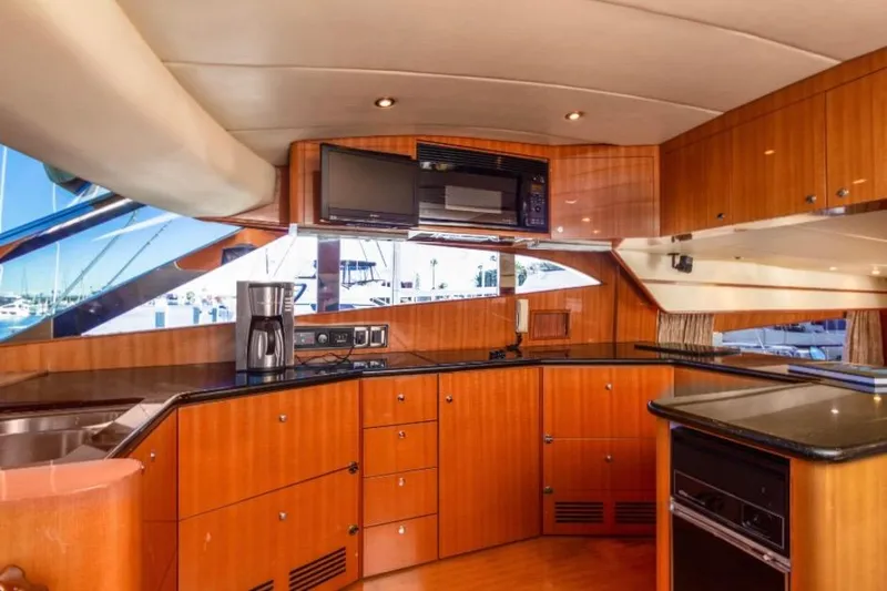  Yacht Photos Pics Luxurious yacht kitchen interior with wood cabinetry, modern appliances, and sleek countertops. Johnson 70, 2005.