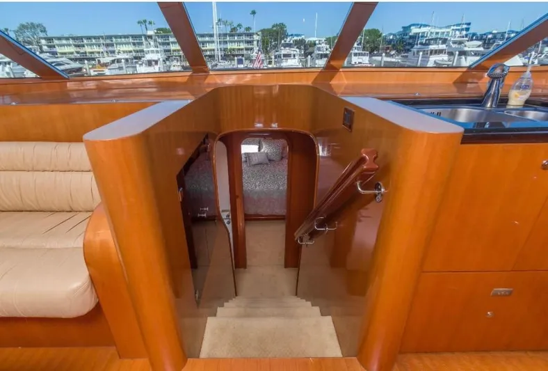  Yacht Photos Pics Interior of a 2005 Johnson 70 yacht, featuring wooden stairs and a cozy seating area.
