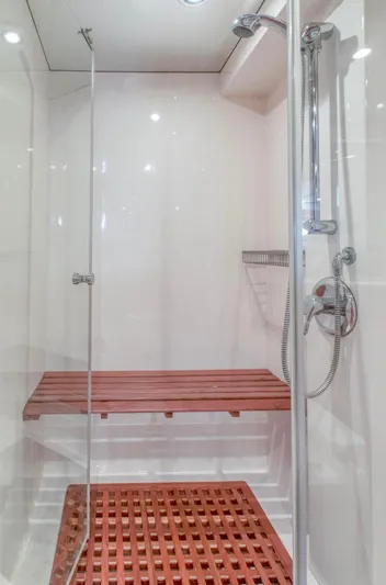  Yacht Photos Pics Modern shower with glass door, wooden bench, and floor in a 2005 Johnson 70 model.